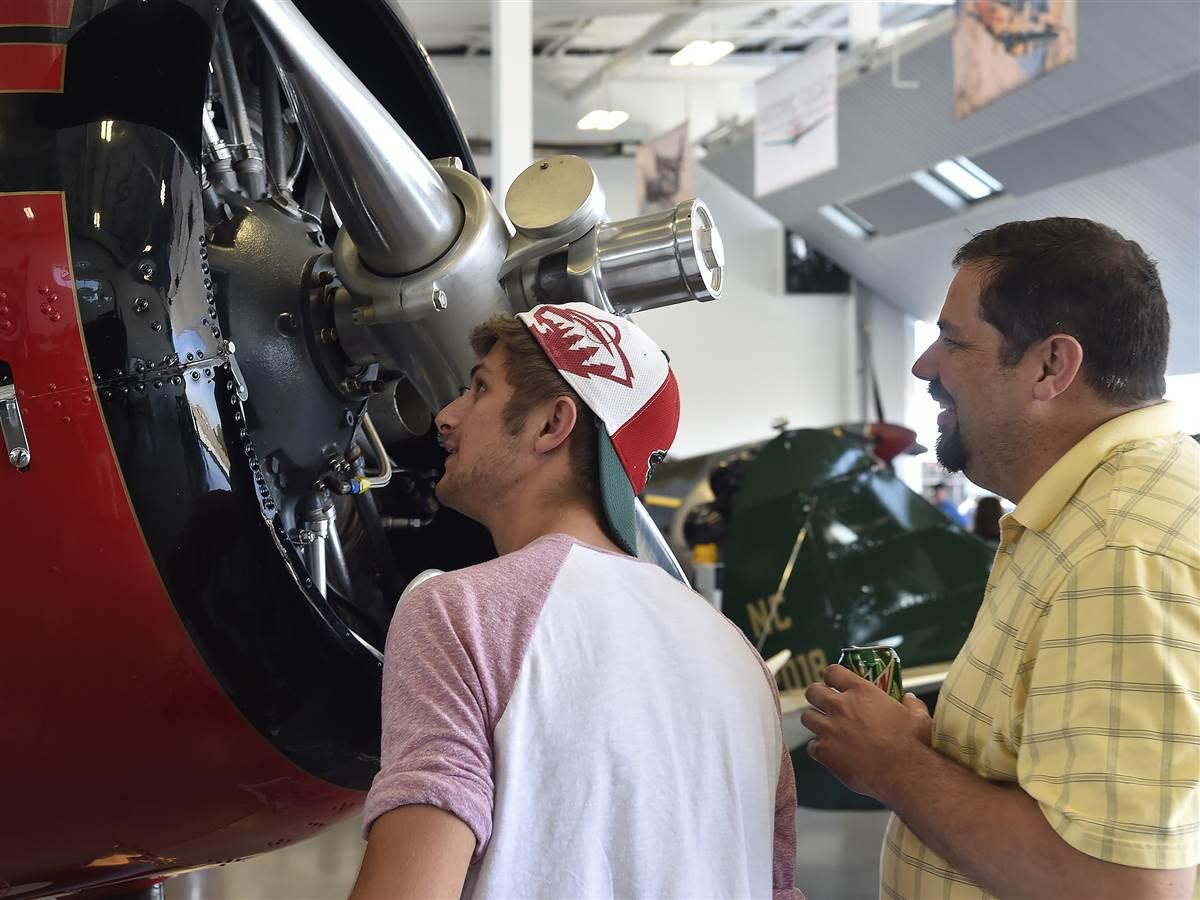 AOPA Fly-In at Bremerton, Washington, attendees Tyler Payne and his father Tim, who arrived commercially from Minneapolis specifically for a VIP Boeing tour, look at the Historic Flight Foundation's Beechcraft D17S Staggerwing in Everett, Washington, during a lunch stop Aug. 19. Photo by David Tulis.