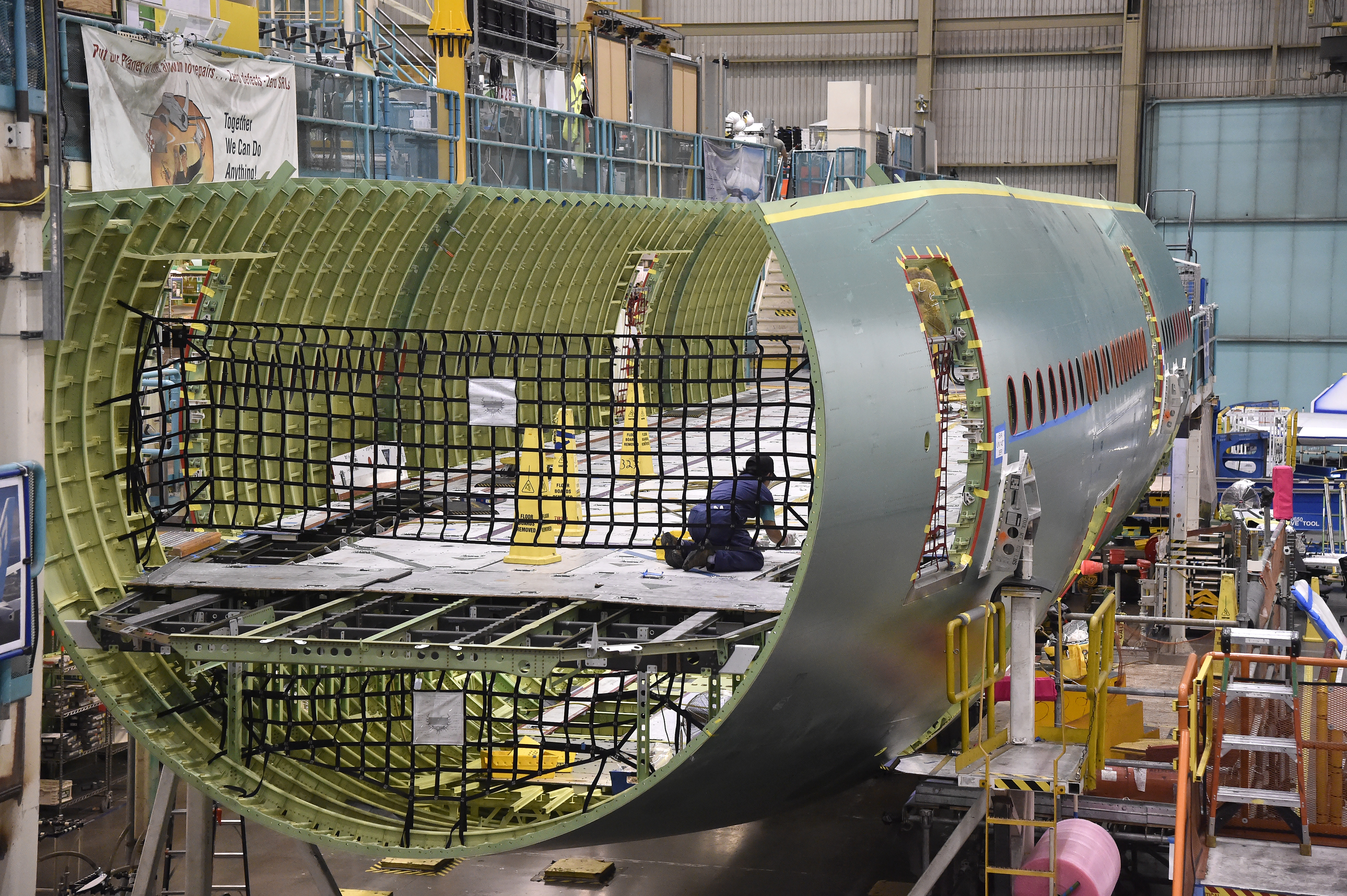 A worker is dwarfed by a fuselage under construction in Boeing's Everett, Washington, factory at Paine Field. Photo by David Tulis.