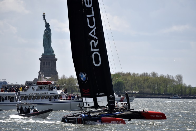 Oracle Team USA sails into the Hudson River past the Statue of Liberty for a Louis Vuitton America's Cup World Series preliminary race in New York City, May 8. Photo by David Tulis.                                                                                                