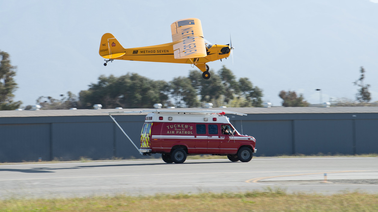 Justin Ramsier drives a 1990 ambulance while Eric Tucker practices landing his J-3 Cub on a platform attached to the ambulance roof. Photo courtesy of Method Seven and Donald Beirdneau.
