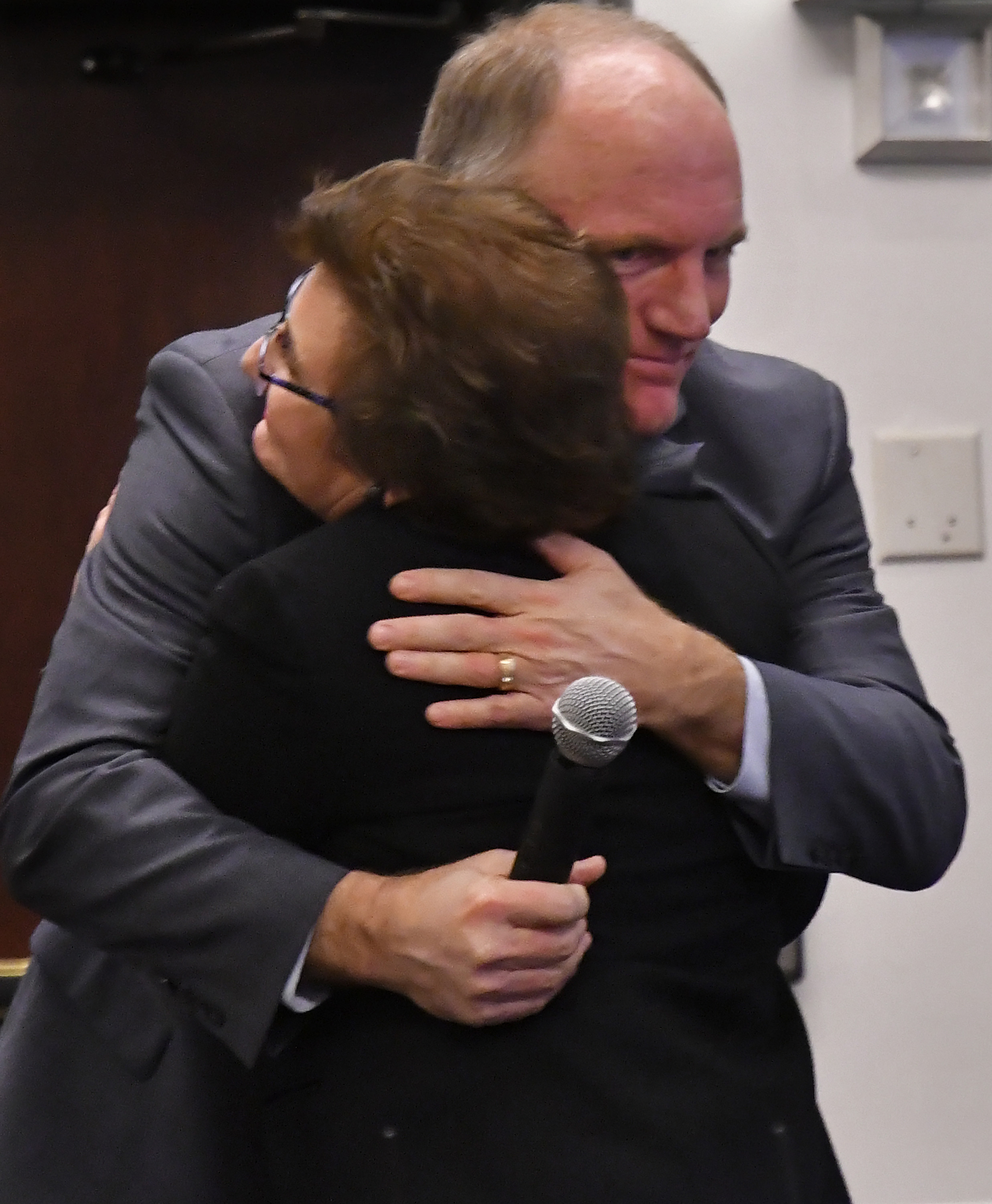 Richard McSpadden, Executive Director of AOPA Air Safety Institute, hugs Joyce Gardella, who helped fund an Air Safety Institute seminar that explores see-and-avoid techniques for pilots in the aftermath of a 2012 Virginia midair collision that claimed her husband, Paul, during a presentation in Fairfax, Virginia, Jan. 10. Photo by David Tulis.