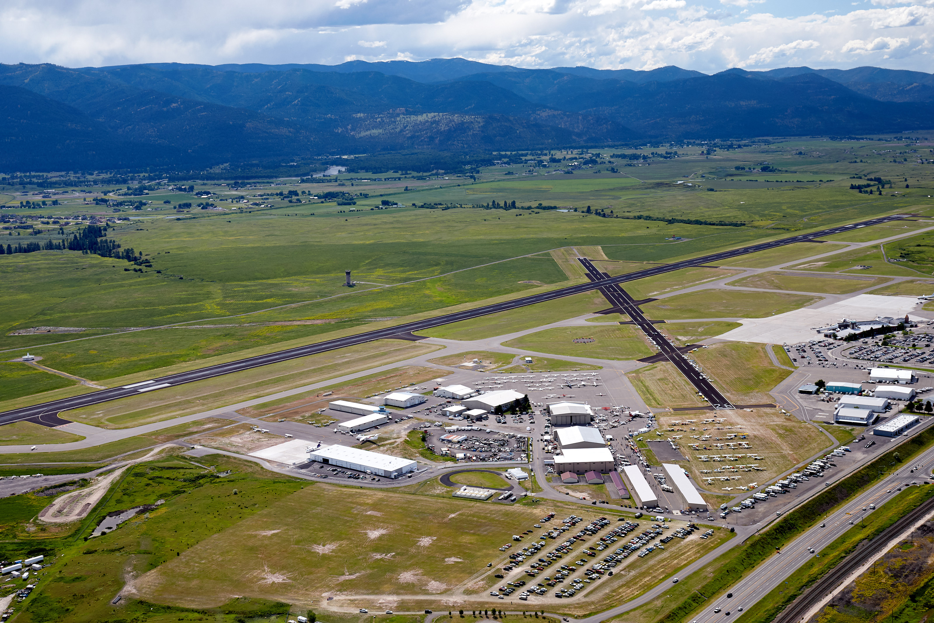 The Northern Rockies provide a dramatic backdrop from  an Aviat Husky piloted by regional sales director Scott Musser during the AOPA Fly-In at Missoula, Montana. Photo by Mike Fizer.