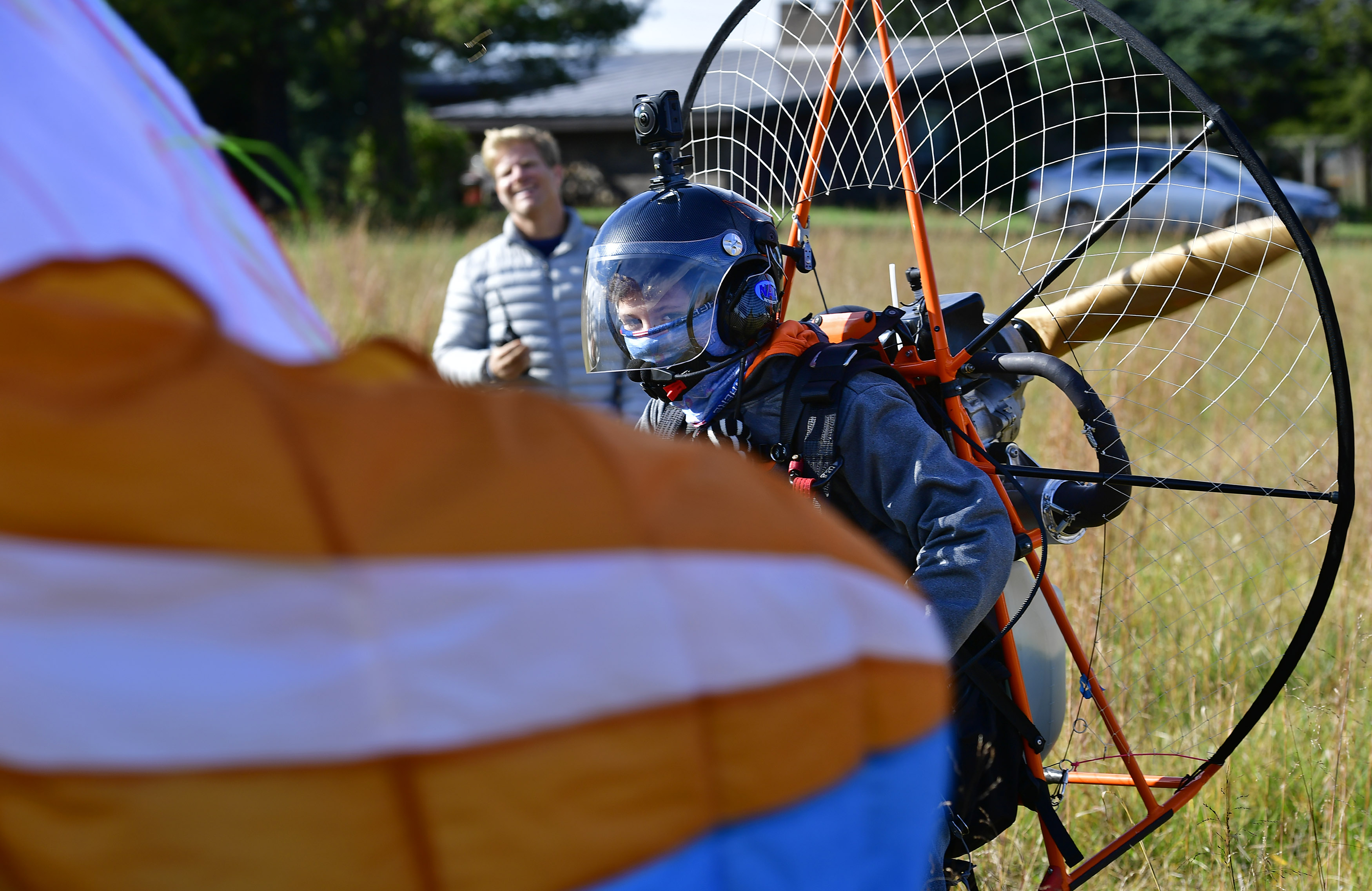 Powered paraglider pilot Henry Scott lands safely under the watchful eyes of his smiling father, Jens. Photo by David Tulis.