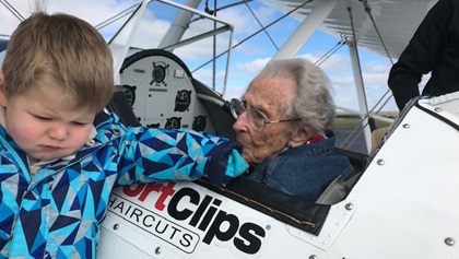 The great grandson of Norma Evans, age 104, visits his grandmother in the cockpit of a Stearman before she went flying. Photo courtesy of the Ageless Aviation Dreams Foundation.