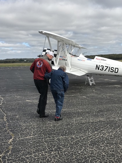 Pilot Darryl Fisher walks Norma Evans, age 104, to an Ageless Aviation Dreams Stearman for her flight. Photo courtesy of the Ageless Aviation Dreams Foundation.