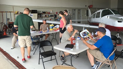 Getting stuck on the way to EAA AirVenture can sometimes create its own adventure. At DeKalb Taylor Municipal Airport, the friendly FBO often hosts impromptu parties for AirVenure-bound pilots, occasionally grilling hot dogs and burgers for transient crews. On this dreary morning, fellow aviators waiting out low ceilings made for a fun gathering. Photo by Chris Eads.