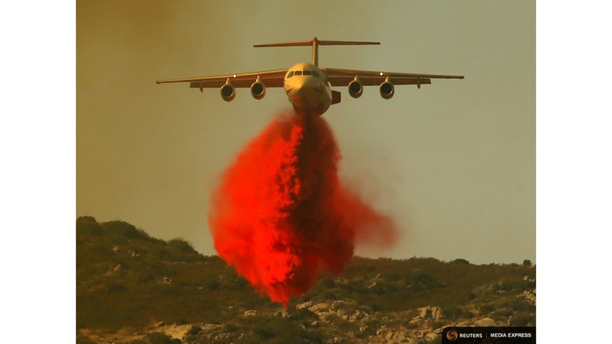 A water bomber makes a drop as firefighters battle a wildfire in temperatures well over 100 degrees Fahrenheit near Potero, California, June 20, 2016. REUTERS/Mike Blake