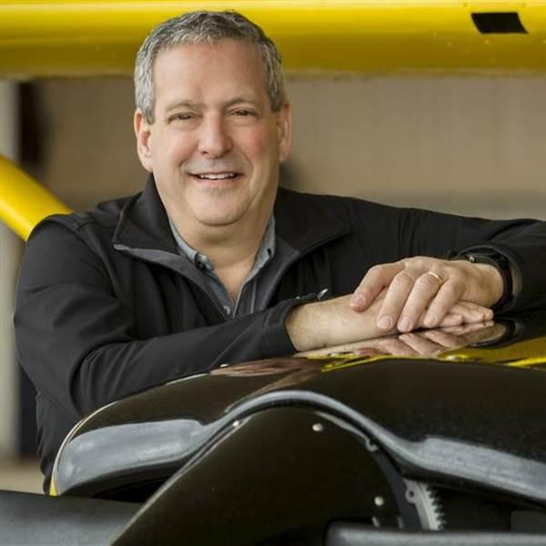 photo of norm isler next to a yellow cessna