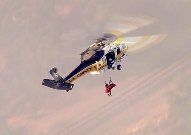 In a dramatic rescue, the County of Los Angeles Fire Department Aviation Unit hoists the driver from the crash site in a Sikorsky S-70A Firehawk. Photo credit: KTLA News via PRNewsFoto/Sikorsky Aircraft