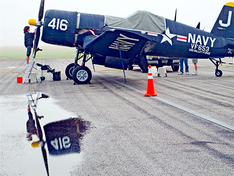 Reflected in a pool of rainwater, the Chance Vought F4U-4 Corsair has been restored as a memorial to Jim Tobul's father, who died in a crash in 2002