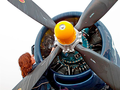 Donna Rowell wipes dew from the restored Chance Vought F4U-4 Corsair owned by Jim Tobul