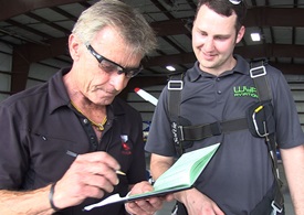 Sean D. Tucker signs Aaron Wypyszynski’s logbook after the flight. 