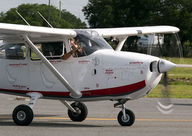 Sean D. Tucker flashes the “hang loose” sign as Nik Oekerman taxis the RedHawk for departure from Plant City Municipal Airport.