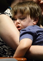 Filmmaker Kim Furst's three-year-old son sleeps while Furst shows her film. Photo by David Tulis/AOPA.