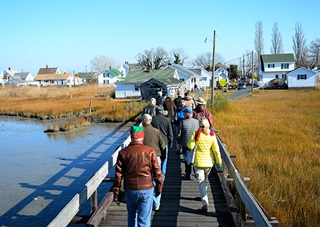 Aviators file across a narrow wooden bridge during the annual Tangier Island Holly Run to the small Virginia island in the middle of the Chesapeake Bay Dec. 5. Photos by David Tulis.