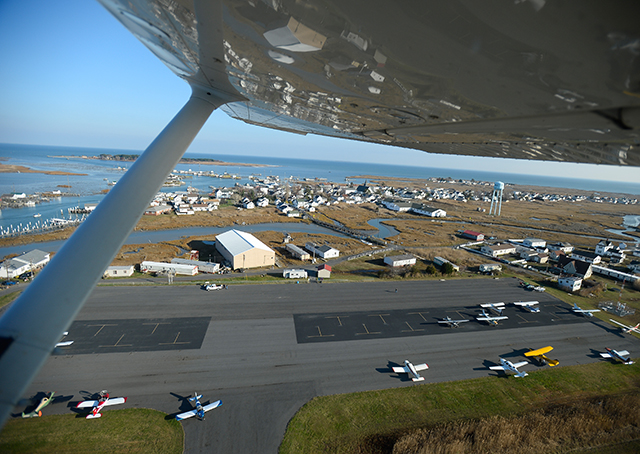 Tangier Island Airport unfolds under the wing of a departing Cessna 172.