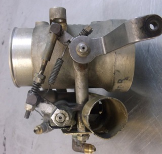 This is the old (leaking) throttle and metering valve. Air passes through the large section at the top and the butterfly valve inside is directly linked to the fuel valve at the bottom. The arm is where the throttle cable attaches. Photo courtesy of Jeff Simon.