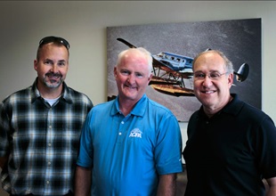 Rick Schwartz (right) and fellow pilot Dan Vossman (left), whom Schwartz brought as a guest for the AOPA Experience package, met with AOPA President Mark Baker during their visit.