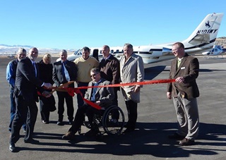 The new Hot Springs County Airport near Thermopolis, Wyoming, opened to the public Nov. 7, ushering in margins of safety and night operations at the gateway to Yellowstone Country. Hot Springs County Commissioner Chair Brad Basse cuts the airport's ribbon and is joined by Former County Commissioner Mike Baker, U.S. Representative Cynthia Lummis (R-Wyo.), County Commissioner Thomas Ryan, U.S. Senator John Barrasso (R-Wyo.), County Commissioner John Lumley, Gov. Matt Mead, Thermopolis native and former Gov. Dave Freudenthal, and GDA Engineers Project Manager Jeremy Gilb. Photo by Warren Hendrickson.