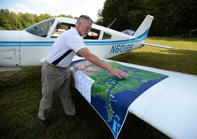 Ed Loxterkamp of Cincinnati, who flew his Piper Arrow to every 2015 AOPA Fly-In, plus EAA AirVenture and the Sun 'n Fun Fly-In, spreads out a map documenting his adventures. Photo by David Tulis.
