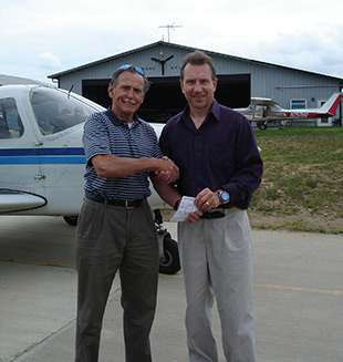 Designated Pilot Examiner Thomas Kijowski congratulates Rick Mihalinac after giving him his temporary private pilot certificate. Photo courtesy of Rick Mihalinac.