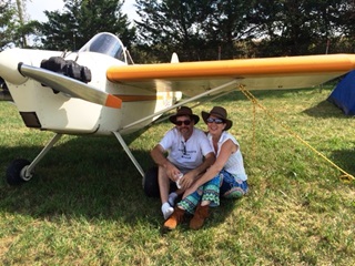 Rob and Laura Bach sit under the wing of their Bentzen Sport at the Antique Airplane Association fly-in.