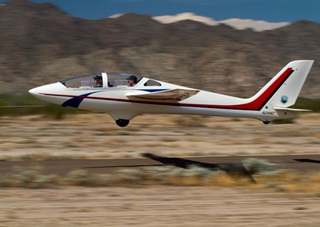 Jason Stephens, flying his MDM-1 Fox glider from the rear seat, is towed skyward with an Arizona Soaring customer at Estrella Sailport Sept. 8. The Fox, a Polish design, is the only glider capable of the full spectrum of aerobatic maneuvers with two on board. Jim Moore photo.