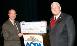 Phil Boyer presents $10,000 scholarship check to Dr. Bruce Smith, Dean of UND School of Aerospace Sciences