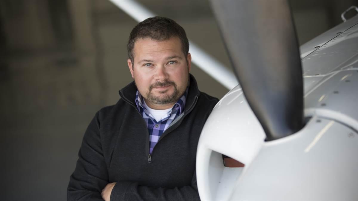 kyle lewis leaning on an airplane prop