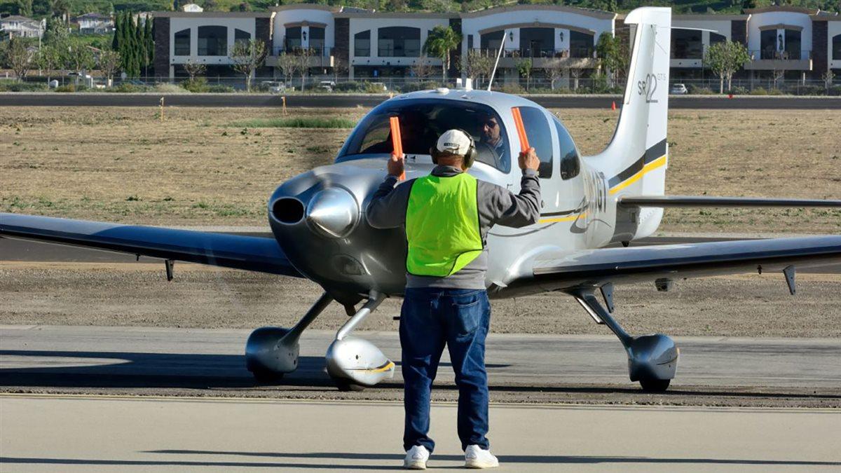 A Fly-In volunteer marshalling an aircraft.
