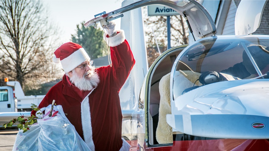 Santa Claus Ralph Hoover loads a Van's Aircraft RV-10 with holly branches during the annual Tangier Island Holly Run organized by Chesapeake Sport Pilot where aviators fly holly branches, presents, and school supplies to the small Virginia island in the middle of the Chesapeake Bay, Saturday, Dec. 10. Photo courtesy of Edwin Remsberg.