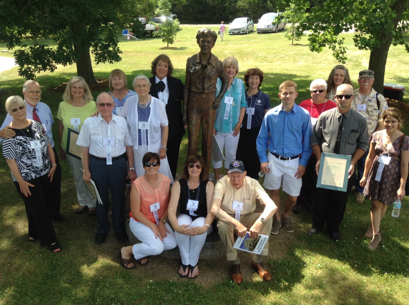 Honorees of the International Forest of Friendship seated from left to right, Cindy Carrigan Apple, Gayle Gorman Green, and Jim Gorman (accepting for the late Marjorie Gorman); standing from left to right, Penny and Ron Blake, Christine Renee Poelma, Fred E. Hetrick, Diane Welch (accepting for herself and Perry Welch), Doris Humphrey Hetrick, Capt. Florence A. Sanders, Ann Shaneyfelt (accepting for Bee Haydu), Dee Bond (accepting for Pamela Ann Collings), James, Gregory, and Joyce Harding (accepting for the late Joyce Autry Harding); and back row right of the statue, Susan Sears (accepting for the late Esther Wyandt) and Debra Plymate and Wayne Nutsch (accepting for the late Glenn Plymate). Honorees Janet Gonzales , Bee Haydu, the late Delores Nusbaum, Senja Robey, and Captain Barry Schiff were not pictured.