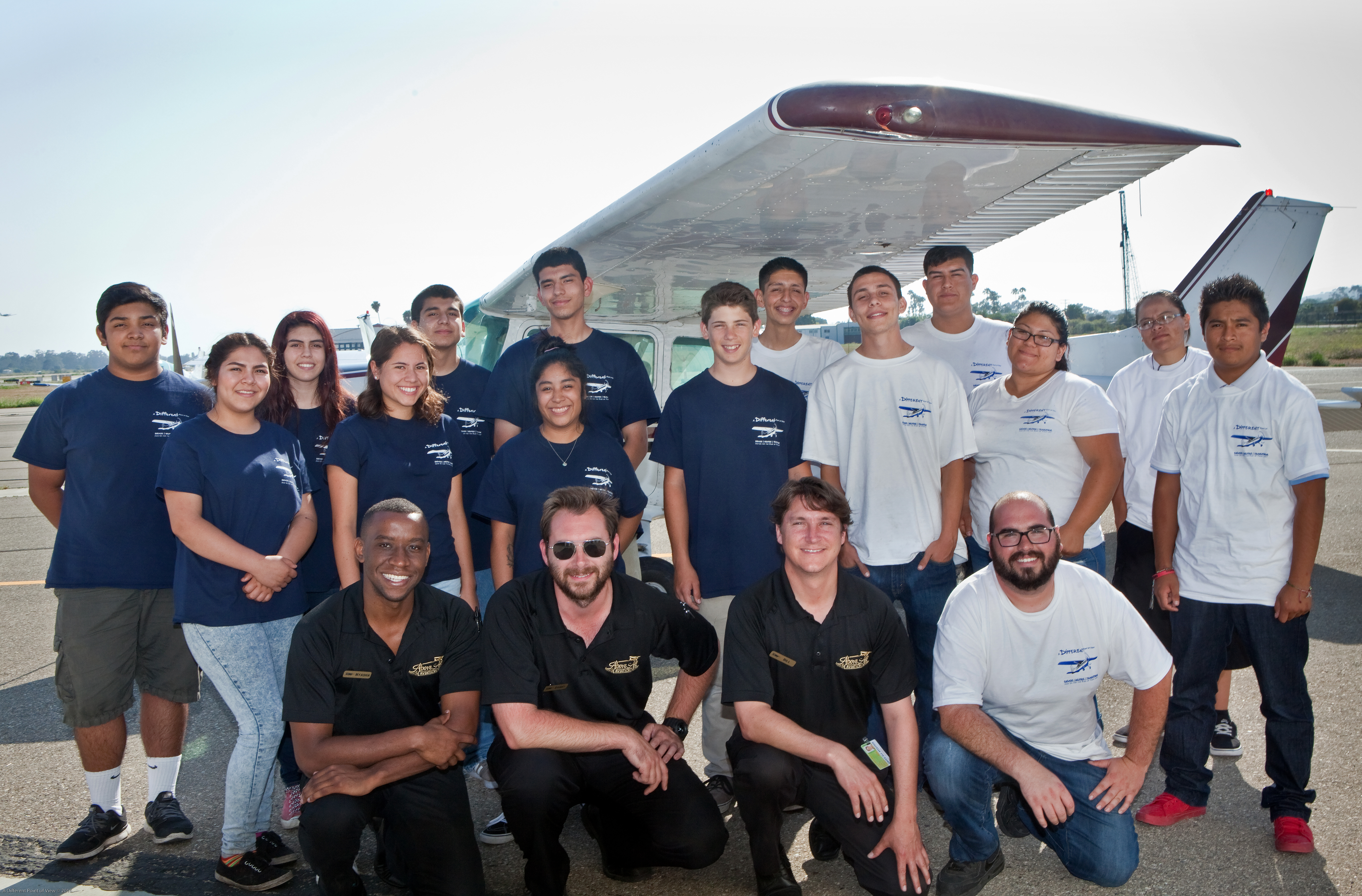 Above All Aviation instructors Nyasha Gutsa, Daniel Malacarne, and William Peterson and mechanic Mike Linhart, front row, pose for a photo with A Different Point of View students and staff during an aviation career day at the Santa Barbara Airport June 25. Photo courtesy of Lynn Houston.