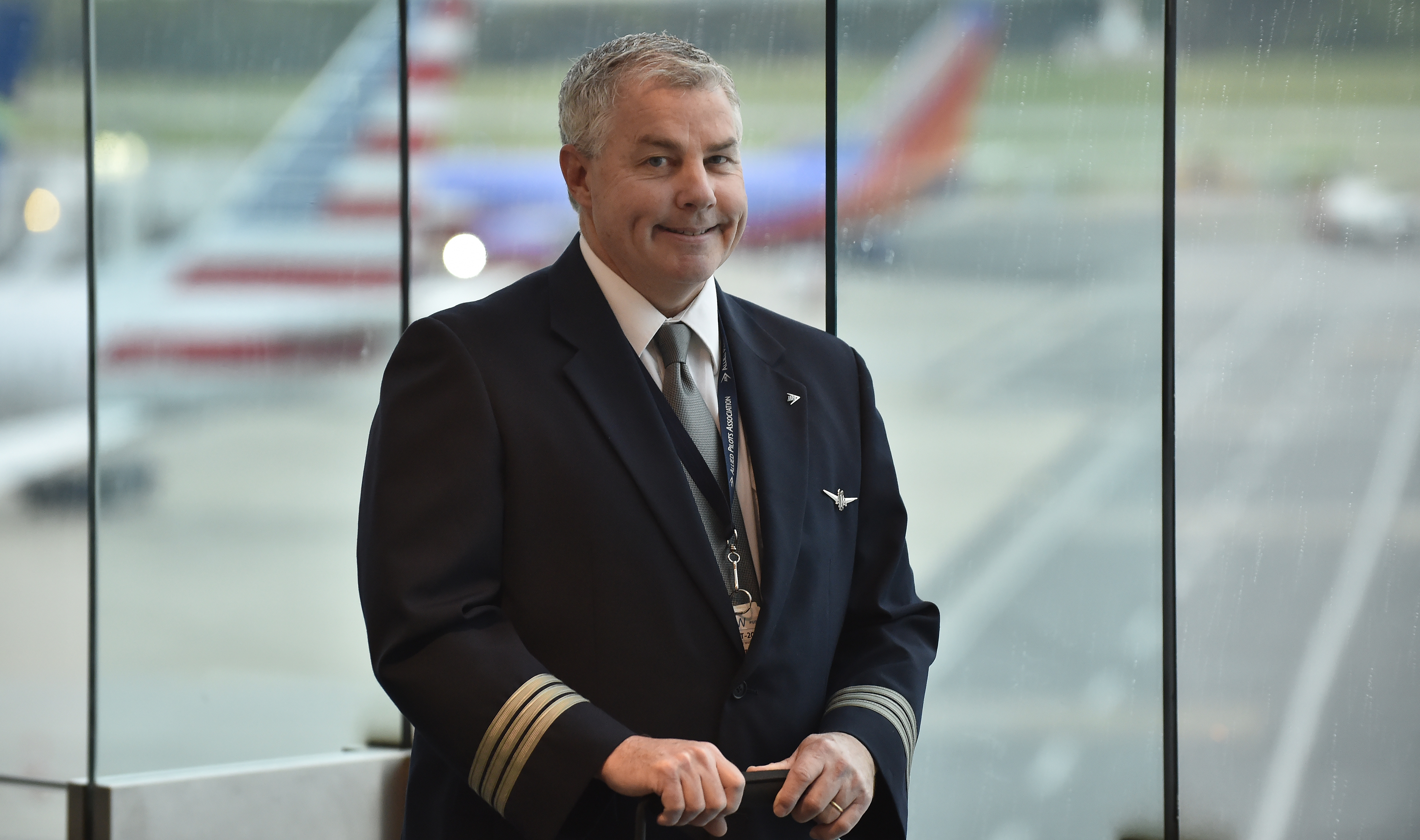 Commercial airliners frame American Airlines first officer Steve Clarke as he pauses for photos at Baltimore/Washington International Thurgood Marshall Airport before a flight to San Francisco May 17. Photo by David Tulis.                                       