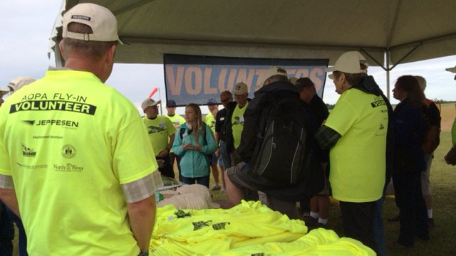 Toni Mensching, center, director of AOPA's Pilot Information Center, meets with airside volunteers. Photo by Jill Tallman.