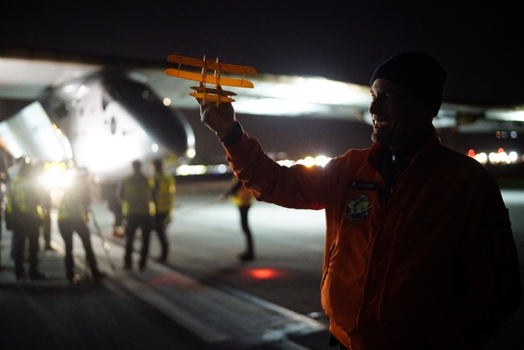 Solar Impulse co-founder Bertrand Piccard holds up a model of the Wright Flyer as André Borschberg disembarks in Dayton, Ohio, May 21. Photo courtesy of Solar Impulse.