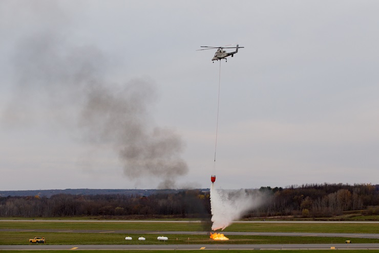 A K-MAX helicopter drops water on a propane-fueled fire during a demonstration at Griffiss Inernational Airport in Rome, New York Nov. 8. Jim Moore photo.