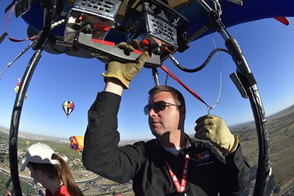 Pilot Colin Graham adds lift to his balloon during the 45th Albuquerque International Balloon Fiesta. Photo by David Tulis.