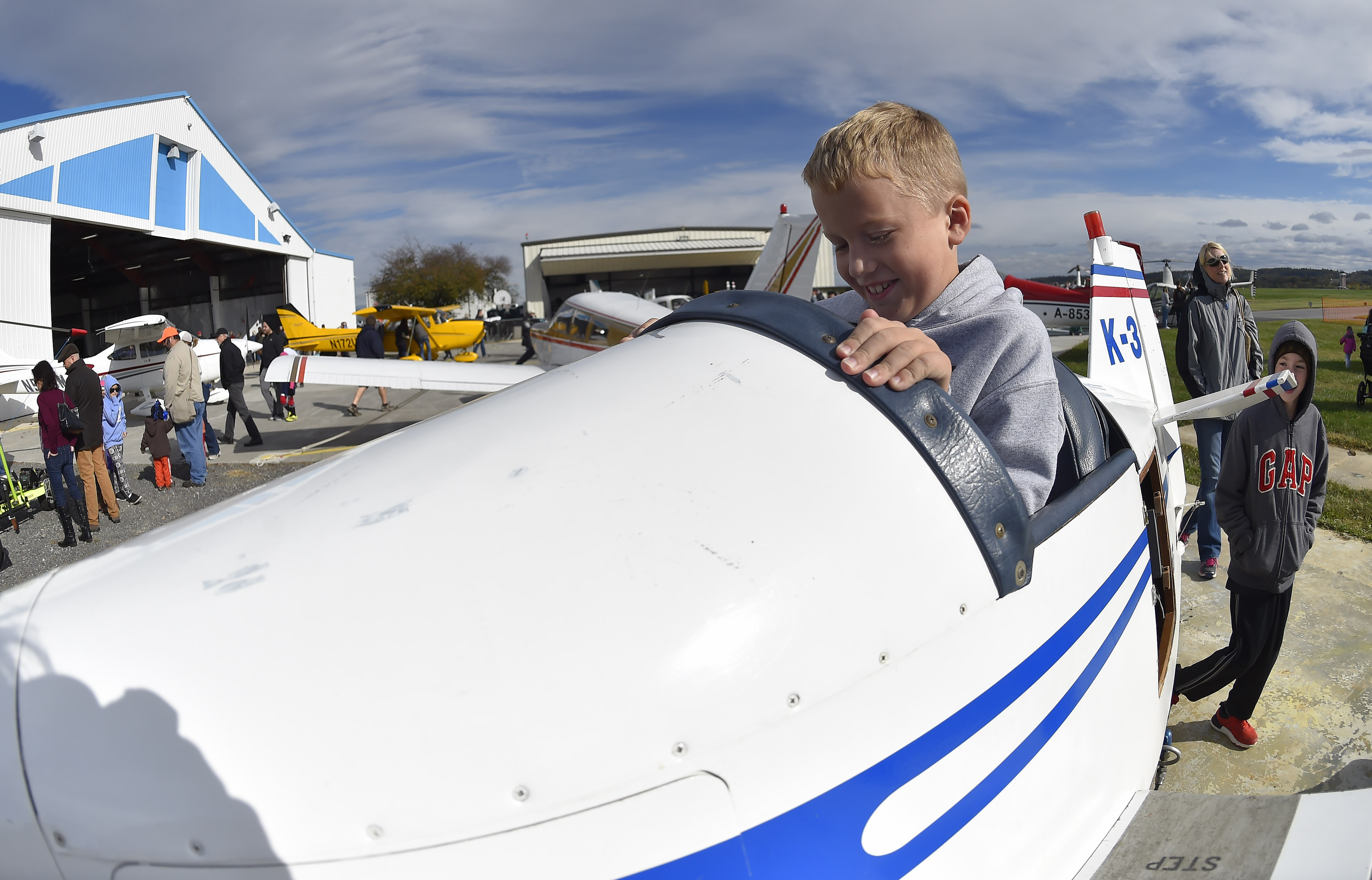 Shane Watson, 10, jumps into a children's-sized full-motion simulator on display at the Wings 'n Wheels community event. Photo by David Tulis.