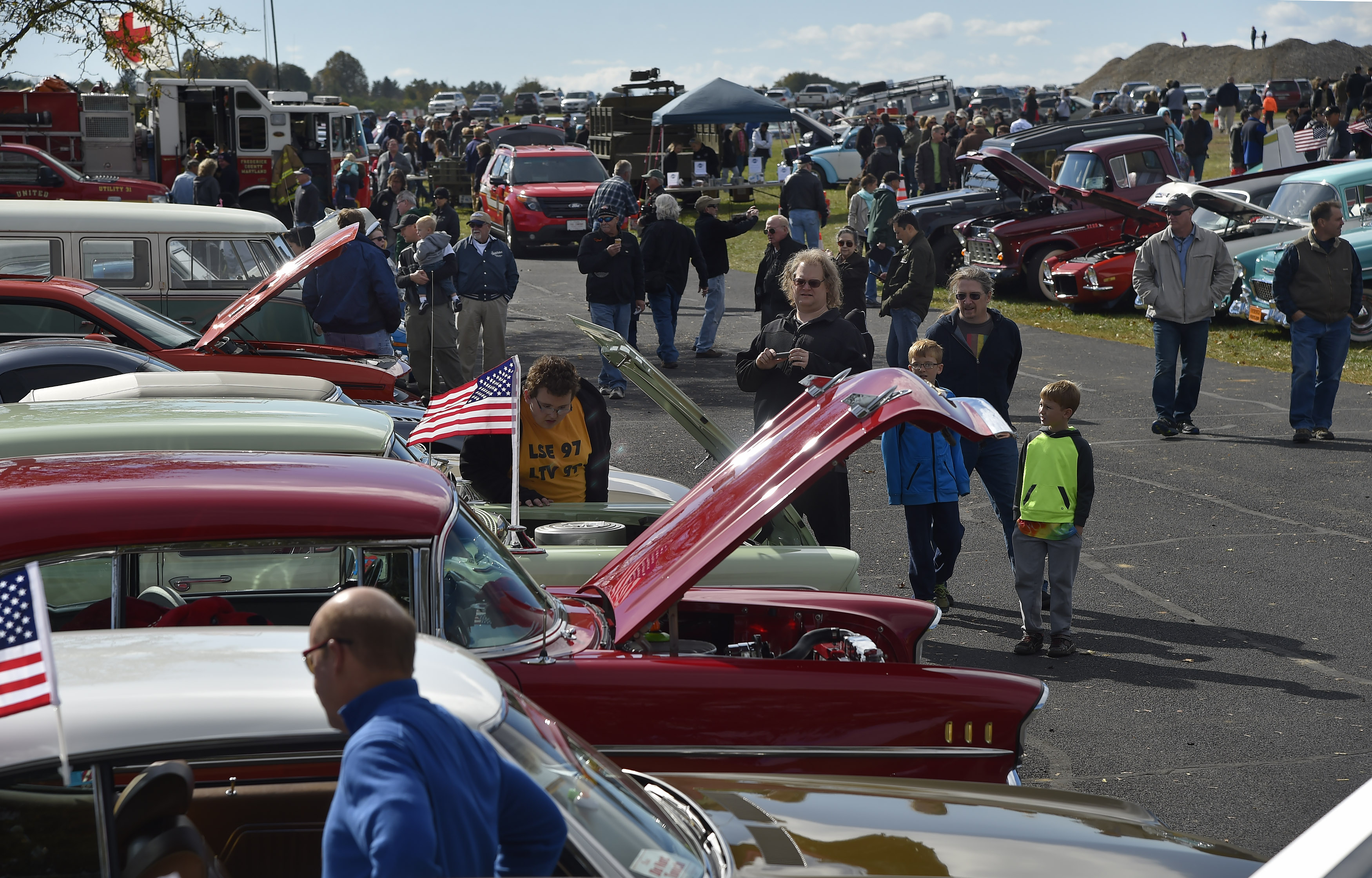 Wings 'n Wheels attendees check out some of the 75 classic and custom cars that joined 18 aircraft and 50 motorcycles showcased at the event. Photo by David Tulis.