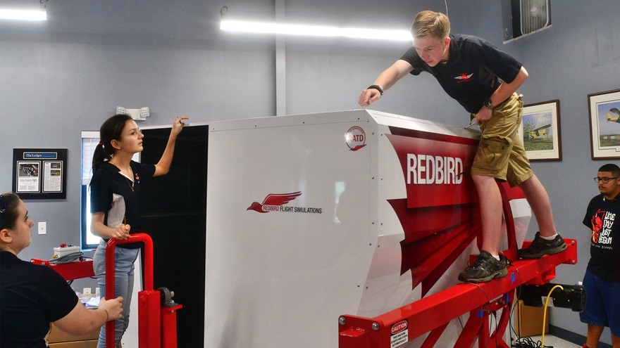 Members of the Lakeland Aero Club, a not-for-profit high school flying club in Lakeland, Florida, build a Redbird FMX simulator. Photo by Mike Collins.