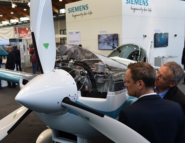 Visitors to the Siemens booth at Aero Friedrichshafen check out the record-setting electric motor. European regulators announced at the show finalization of new certification rules that will speed the arrival of new technology and reduce its cost. Photo courtesy of Messe Friedrichshafen/Aero Friedrichshafen.