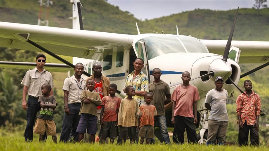 Air Serve International pilots are surrounded by a welcoming and curious group of villagers. Photo by Chris Rose.