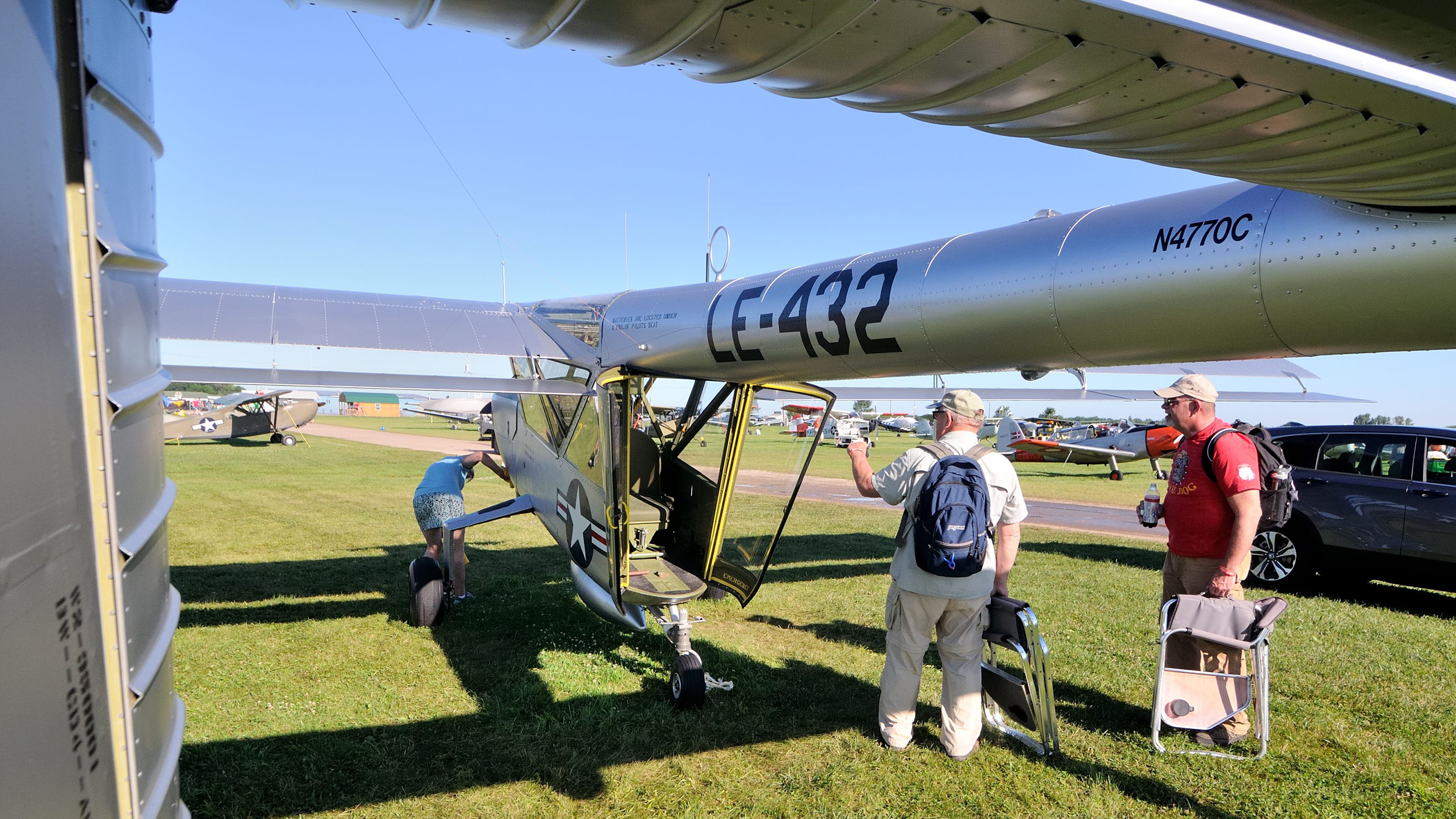 Visitors to AirVenture 2017 look at Keith and Kathy Brunquists' Boeing YL-15 Scout prototype. Glass clamshell doors enclose the observer's seat, which can rotate to face aft or forward.