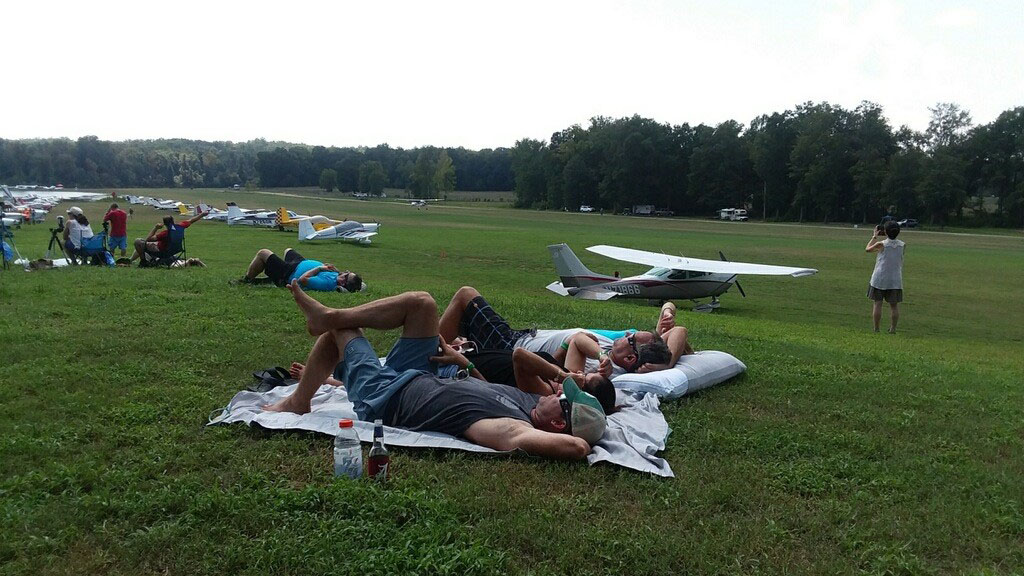 Spectators lay out on a hill overlooking the runway, but they aren't interested in watching landings. They have their protected eyes fixed on the solar eclipse. Photo by Alyssa Cobb.