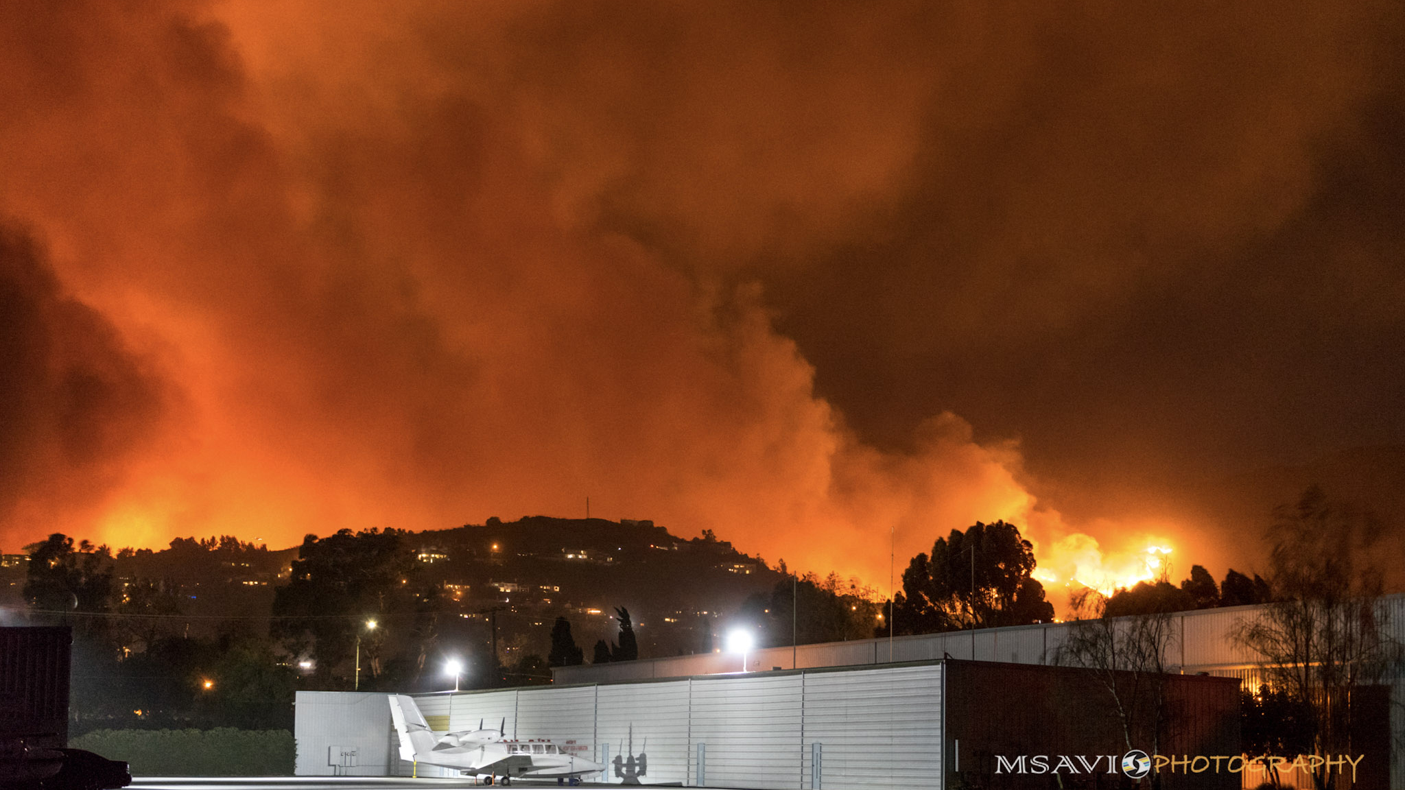 Flames and smoke rise near California's Santa Paula Airport, a base of operations for firefighters battling the nearby Thomas Fire. Photo by Mike Salas, MSAVI Photography and Focal Flight.