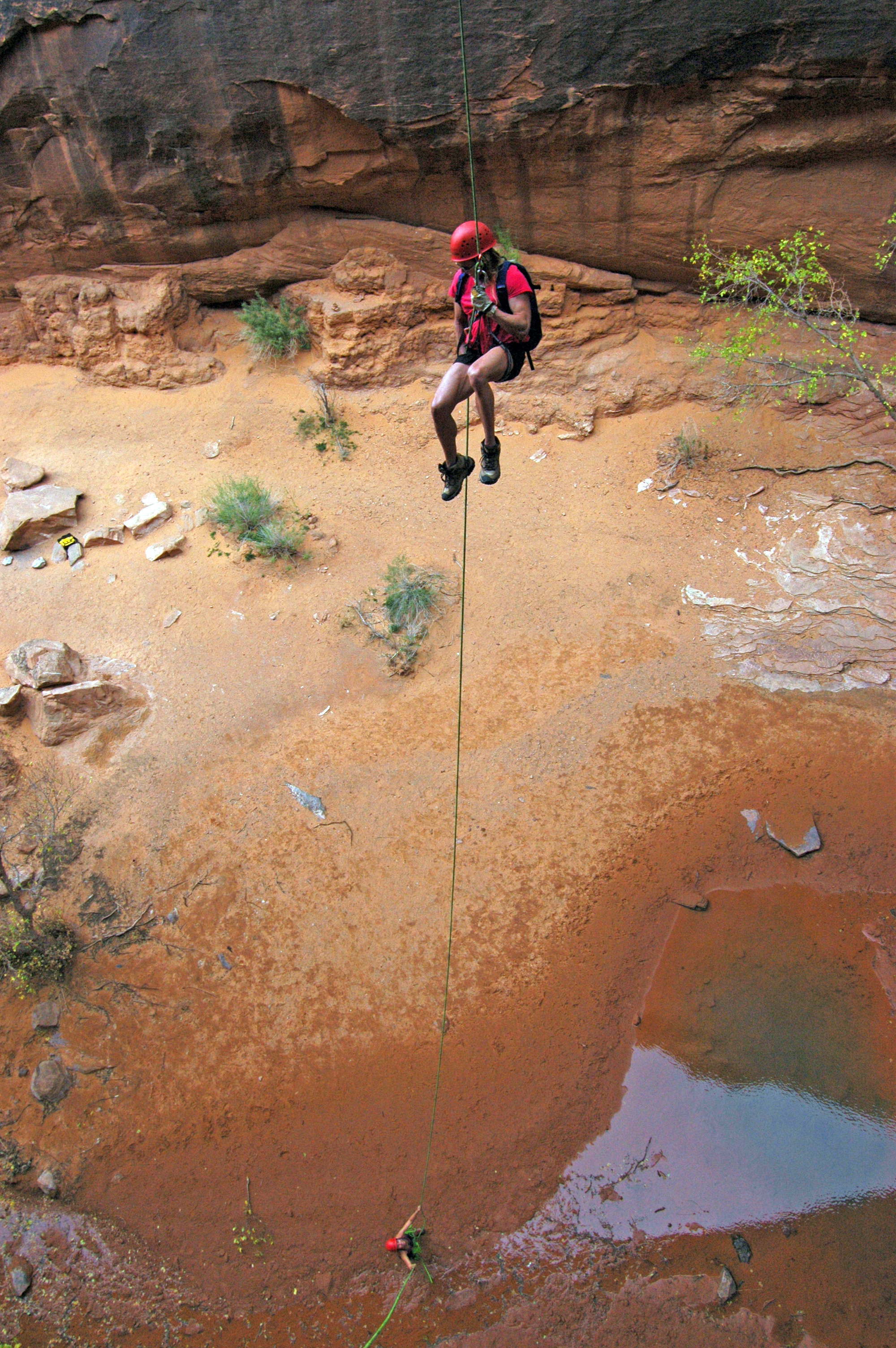 The author rappels off Morning Glory Arch, just south of Arches National Park. Morning Glory is about 100 feet high, with a span of 243 feet. Photo by Herb Crimp, Desert Highlights.
