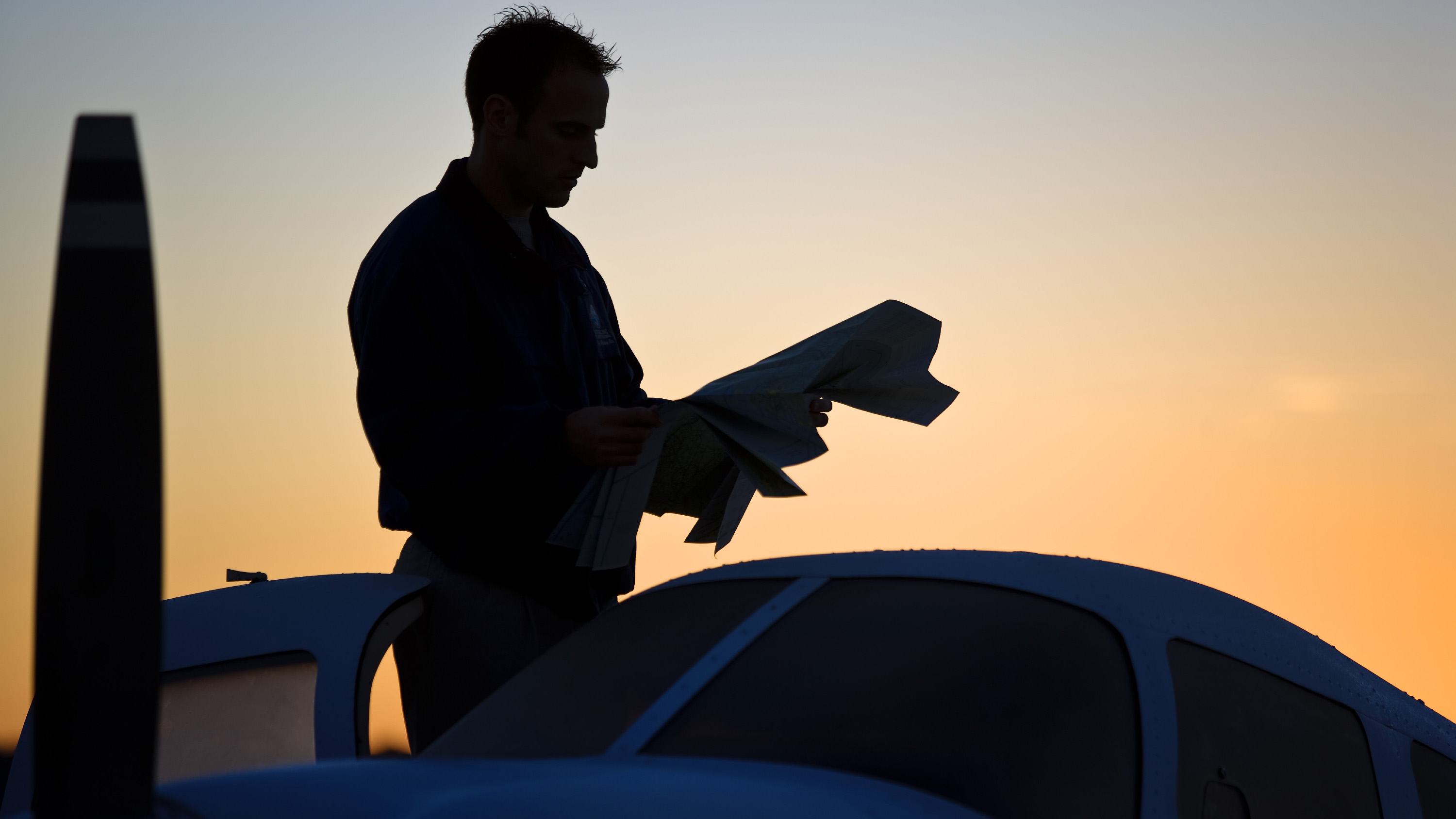 A pilot looking at a sectional while standing on the wing of a Piper at Sterling Flight Center in Jacksonville, Florida. AOPA file photo by Mike Fizer.