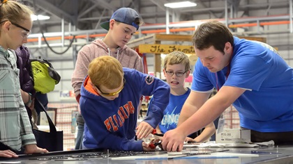 Volunteer Griffin Kellar, right, who works as an A&P mechanic, helps young people rivet letters onto a sign at an Alaska Airmens Association workshop during the Great Alaska Aviation Gathering. Photo by Mike Collins.