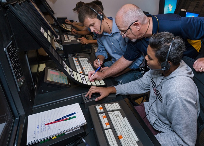 Embry-Riddle Aeronautical University professor and Air Traffic Management program coordinator William Coyne works with students Roemer Santos and Brandon Liden on new air traffic control equipment in the en route lab on the Daytona Beach campus. Photo courtesy of Daryl LaBello, Embry-Riddle Aeronautical University.